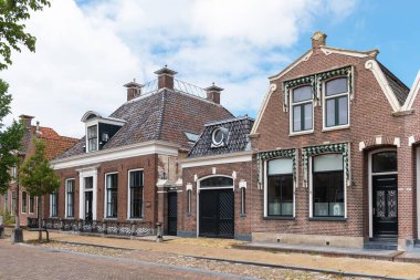 Workum, Friesland / The Netherlands - 16 Temmuz 2020: Yazın şehrin ana caddesindeki geleneksel evler
