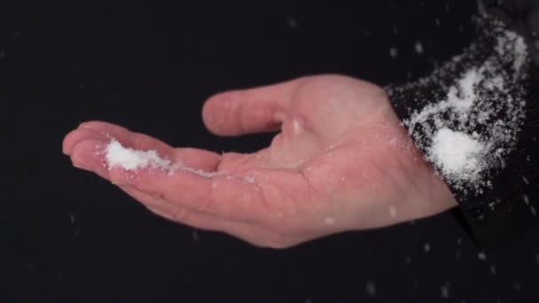 Снежинки падают на руки мужчин — стоковое видео