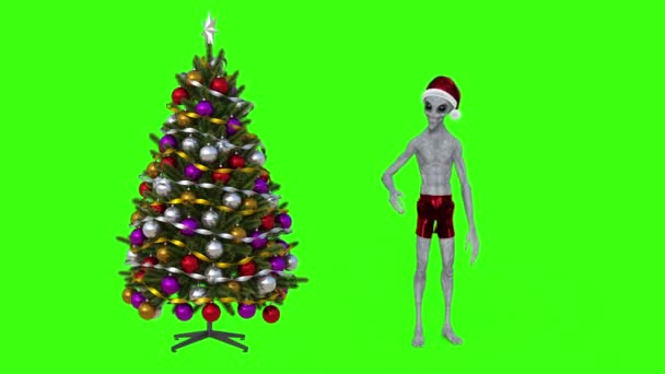Alien in de buurt van Treealien in de buurt van kerst kerstboom, groene achtergrond — Stockvideo