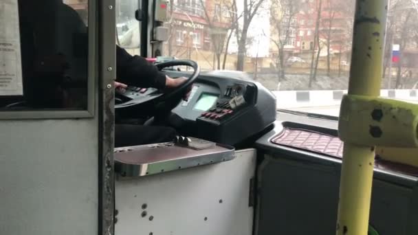 Водитель водит пассажирский автобус по городу — стоковое видео