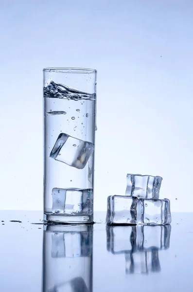 Ice cubes splashing into glass