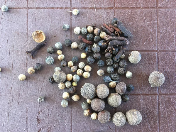 There are dry spices for salting on an old brown chopping Board. pepper, cloves, coriander — Stock Image Dry Spices Salting Old Brown Chopping Board Pepper Cloves Coriander Stock Photo