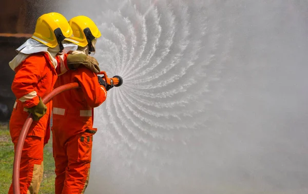 Dois Bravos Bombeiros Usando Extintor Água Mangueira Para Combate Incêndio — Fotografia de Stock