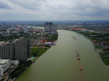 Şehir manzaralı Chao Phraya Nehri 'ndeki büyük kargo gemisinin havadan görüntüsü, yağmur mevsiminde yeşil suyu olan nehir, kopyalama alanı, Üst Manzara, Bangkok, Tayland.