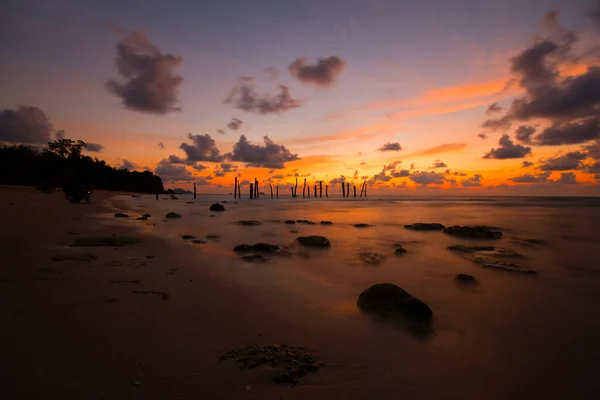 Beautiful sunset sunrise over the sea with old wooden bridge and rocks. Bright dramatic sky with clouds. Landscape under scenic colorful sky at sunset dawn sunrise, Sun over skyline, Horizon-Image