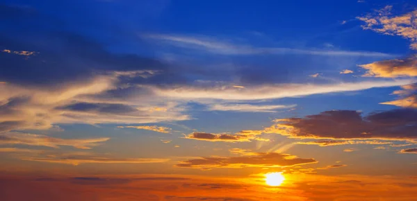 空の雲 オレンジと赤の劇的な色を通して太陽の空の青とオレンジの光で美しい夕日 — ストック写真