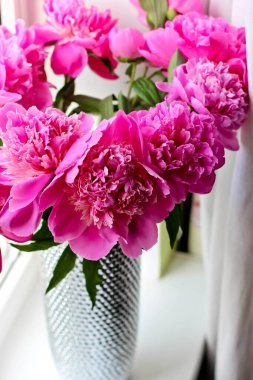 Gümüş vazoda pembe şakayıklar