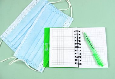     Boş not defteri ve tıbbi maske üst görünümü         