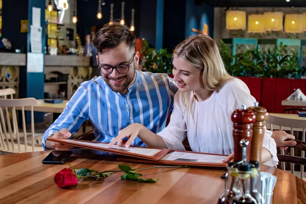 Güzel, romantik bir restoranda yemek sipariş eden genç ve mutlu bir çift. Güzel yemek konsepti.