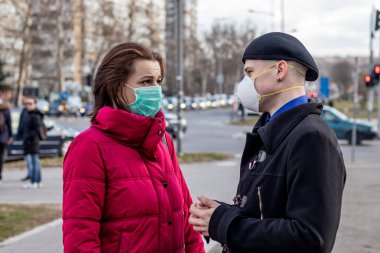Koronavirüs, sis ya da diğer atmosferik kirleticilerden korunmak için iki çeşit koruyucu maske takan genç bir çift. Ekoloji ve Covid 19 salgını hakkında kavramsal fotoğraf (salgın).