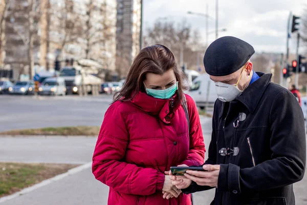 Молодая Пара Читает Новости Мобильного Телефона Одетая Два Типа Защитных — стоковое фото