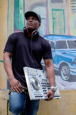  Modern DJ piknik malzemeleri olan Kübalı disk jokeyi sokak boyama sanatının önünde..