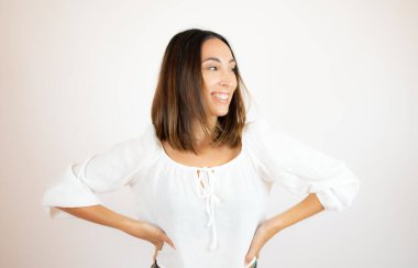 Beyaz gömlekli güzel bir kadın gülümsüyor.