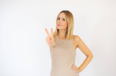 Bej elbiseli güzel sarışın kadın jest yapıyor.