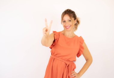 Beyaz arka planda turuncu elbiseli güzel bir kadın.