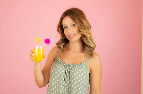 Woman with a cocktail on pink background