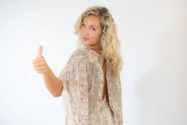 Beyaz arka planda, parti elbisesi içinde gülümseyen güzel sarışın kadın.