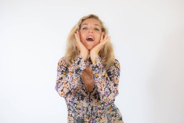 Beyaz arka planda beliren çiçekli elbiseli güzel sarışın kadın.