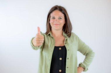 Yeşil bluzlu kadın parmak hareketi yapıyor.