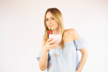 Güzel bir kadın çilekli kokteyl içiyor.