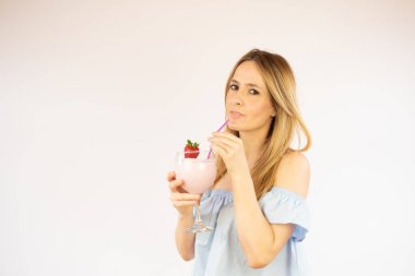 Güzel bir kadın çilekli kokteyl içiyor.