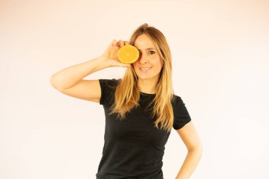 Gülümseyen güzel kadın portakalı gösteriyor