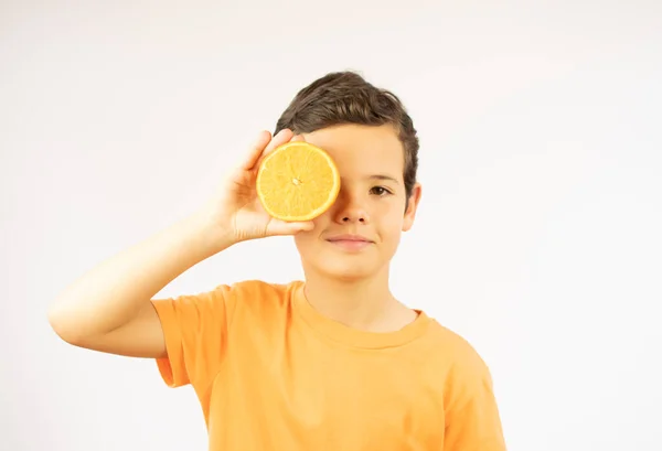 Smiling boy showing an orange