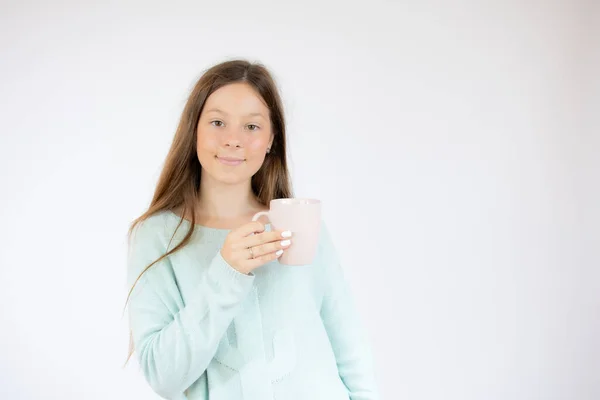 Smiling girl with a cup on white background