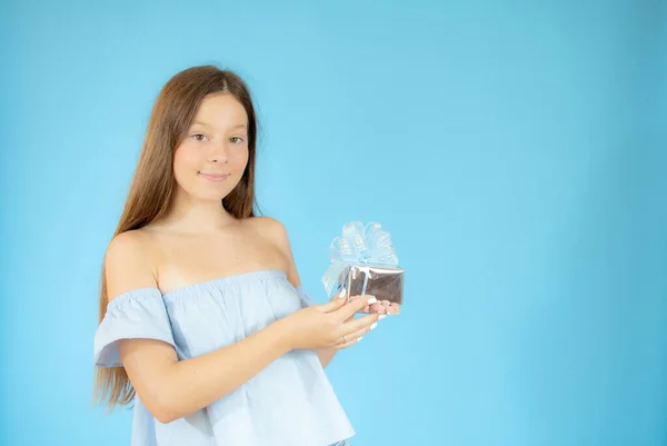 Sonriente Hermosa Chica Mostrando Regalo Sobre Fondo Azul —  Fotos de Stock