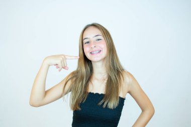 Siyah bluzlu gülümseyen kız dişlerini gösteriyor.