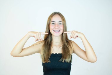 Siyah bluzlu gülümseyen kız dişlerini gösteriyor.