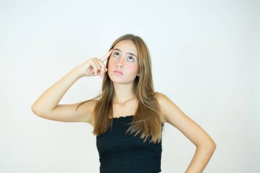 Beyaz arka planda şüpheli jestleri olan güzel bir kız.