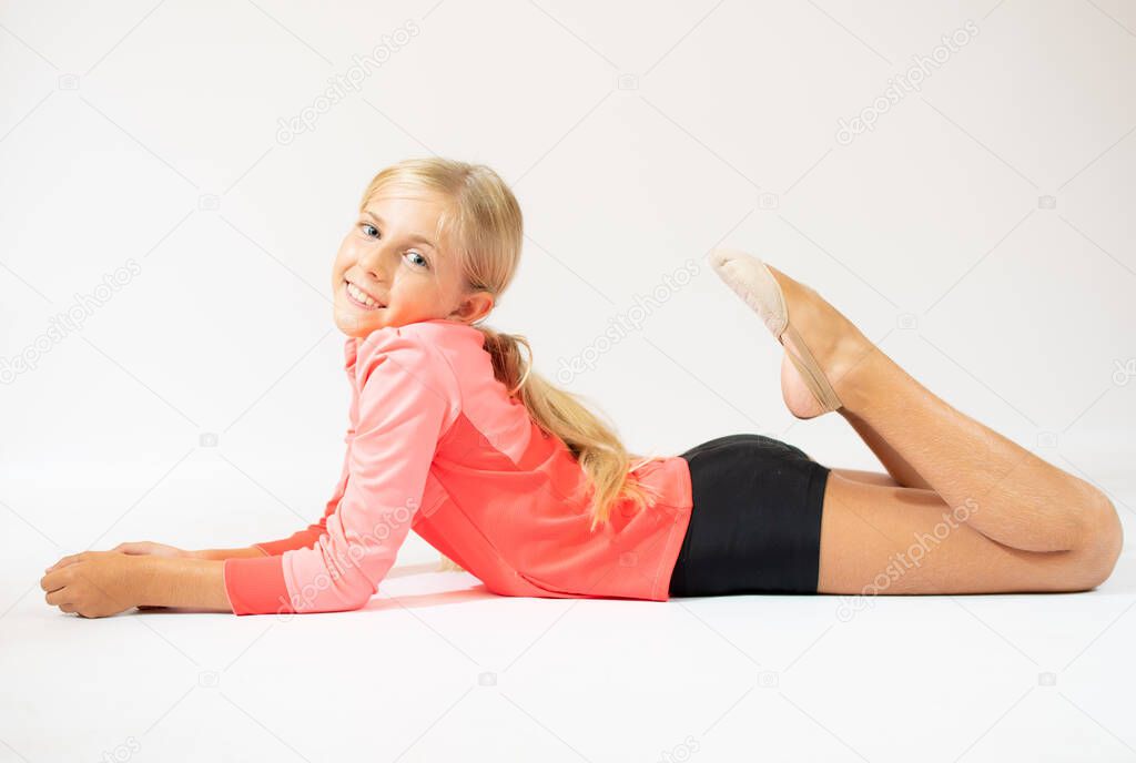 Blonde girl in sportswear doing stretching on the floor