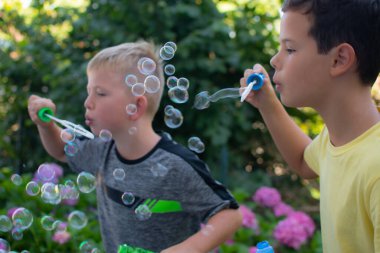 Doğada kabarcıklar çıkaran iki küçük çocuk.