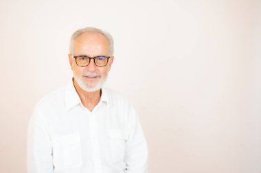 Gözlüklü, beyaz gömlekli, gülümseyen son sınıf öğrencisi.