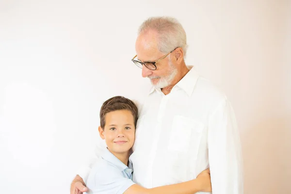 Usmívající Chlapec Objímá Svého Dědečka Bílém Pozadí — Stock fotografie