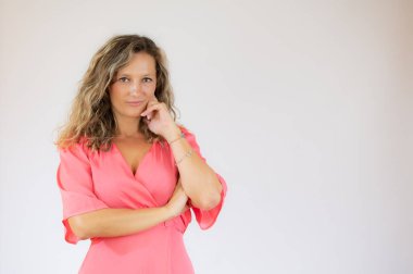 Pembe elbiseli güzel bir kadın şüpheli bir jest yapıyor.