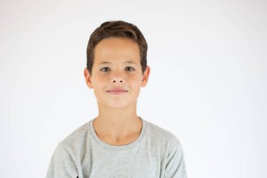 Stüdyoda poz veren güzel bir çocuk. Beyaz arka planda 9 yaşındaki anaokulu öğrencisinin fotoğrafı