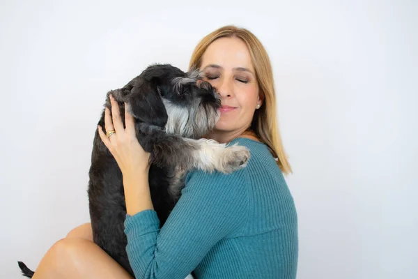 可爱的年轻女子亲吻并拥抱她的小狗雪纳犬 主人和狗之间的爱 被白色背景隔离 工作室肖像 — 图库照片