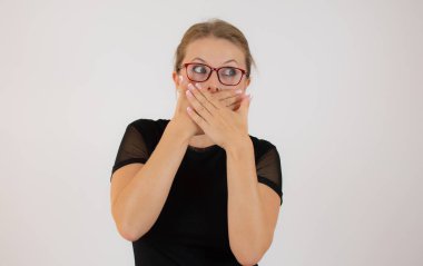 Güzel kız beyaz arka planda ağzını kapatıyor.