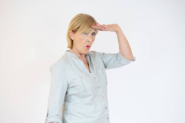 Sarı arka planda, yüzünde şaşkın bir ifade olan son sınıf öğrencisi kadın.