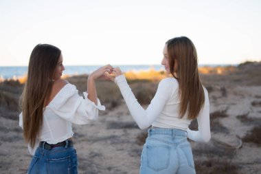 Sırtı denize dönük iki kız. Özgürlüğü ve neşeyi hissetmek