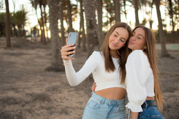 Dvě Šťastné Přítelkyně Dělat Selfie Parku Při Východu Slunce Teplým — Stock fotografie