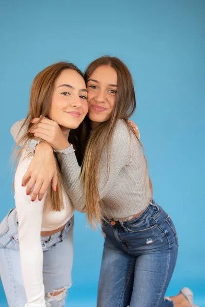 Mutlu Gülümseyen Genç Kızlar Mavi Arka Planda Sarılıyorlar — Stok fotoğraf