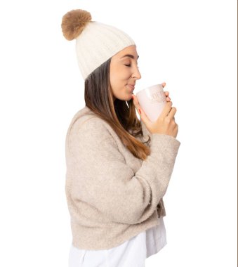 Şeffaf arka planda duran, kışlık giysiler içinde sıcak içeceğe üfleyen genç bir kadının yan görüntüsü. PNG şeffaf.