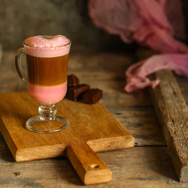 lattebeetroot (beet juice) - pink coffee with milk in a transparent cup on the table.