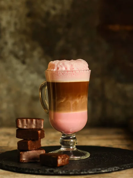 lattebeetroot (beet juice) - pink coffee with milk in a transparent cup on the table.