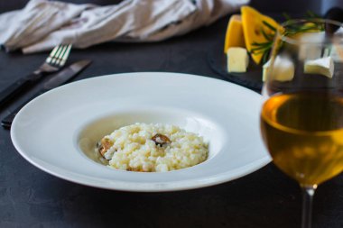 beyaz bir tabak ve bardak beyaz wineon karanlık bir arka plan risottowith midye (deniz ürünleri pirinç)