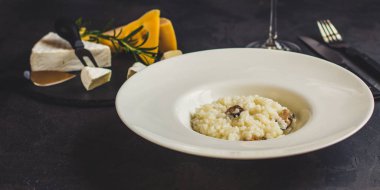 beyaz bir tabak ve bardak beyaz wineon karanlık bir arka plan risottowith midye (deniz ürünleri pirinç)