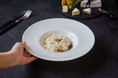 beyaz bir tabak ve bardak beyaz wineon karanlık bir arka plan risottowith midye (deniz ürünleri pirinç)